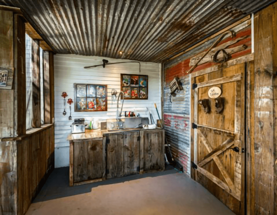 Rustic kitchen area with a wooden counter, sink, and vintage decorations.