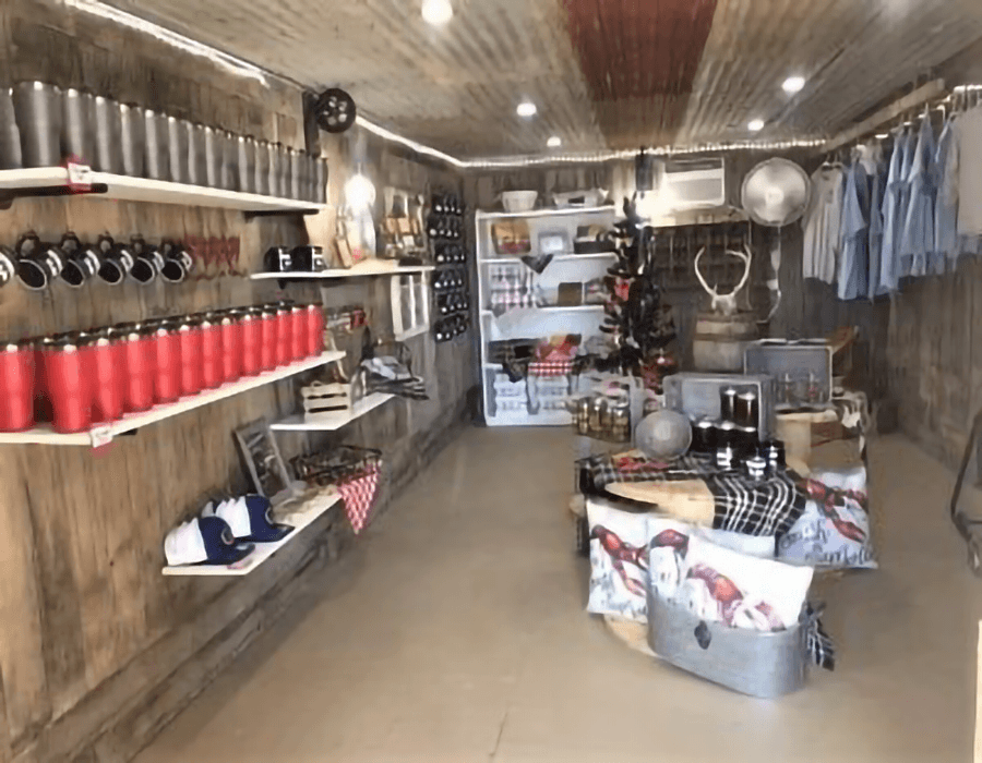 A rustic store interior displaying various merchandise including cups, clothing, and home goods on wooden shelves.
