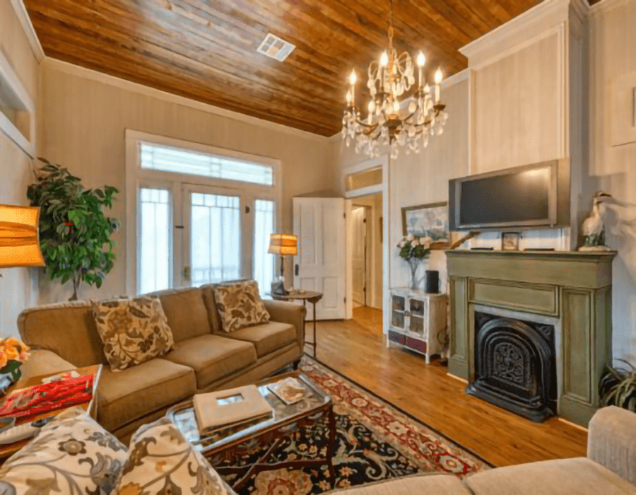 Cozy living room featuring a sofa, ornate chandelier, and a decorative fireplace.