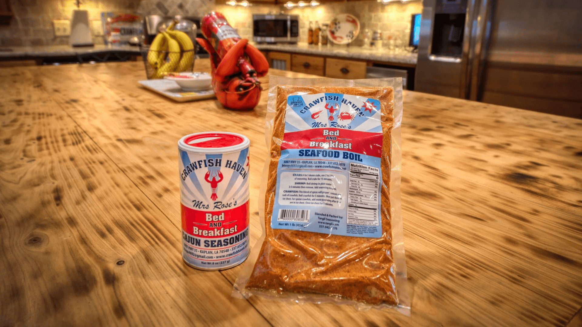 A can of Mrs. Rose's Crawfish Haven Cajun Seasoning and a package of Seafood Boil on a wooden countertop.