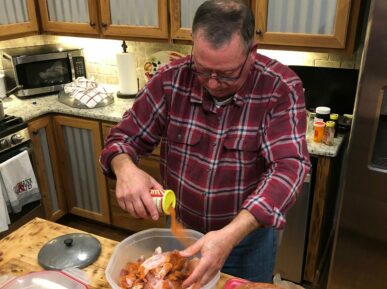 Barry Toups seasoning food while preparing Cajun Meal